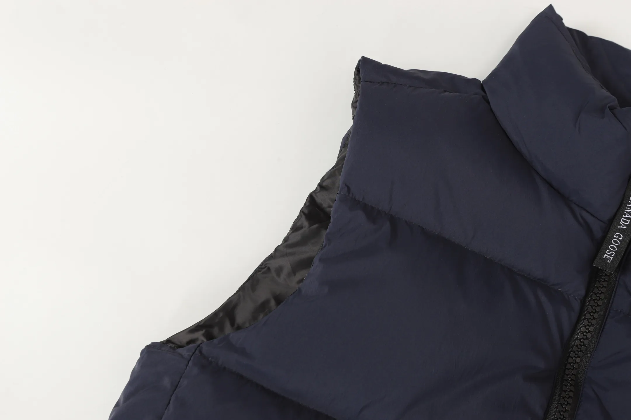 P560 Canada gooes Lawrence down vest (high version) The Lawrence down vest features a durable shell and quilted body, making it a must-have item for all seasons. The fabric has a durable soft touch. Longer hem at back for added protection. Reflective double-stripe grip tape at back. The Lawrence features an engineered down-filled collar to block strong winds, a two-way front zip and a longer rear hem.  Color: black with red label, black with black label, desert color, ocean blue Size: XS-2XL